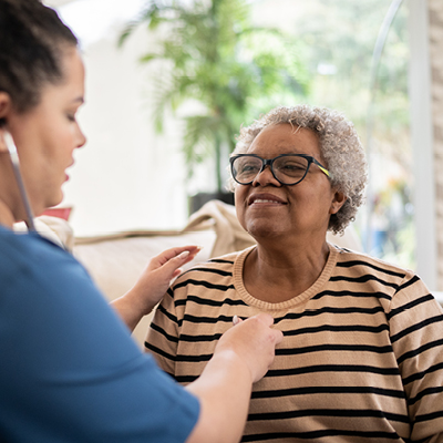Woman in a striped shirt getting checked by a nurse