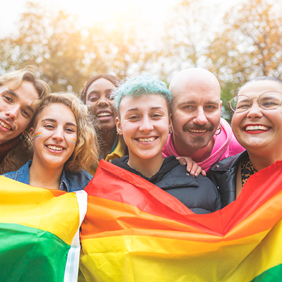 Group of people infront of a Pride Flag